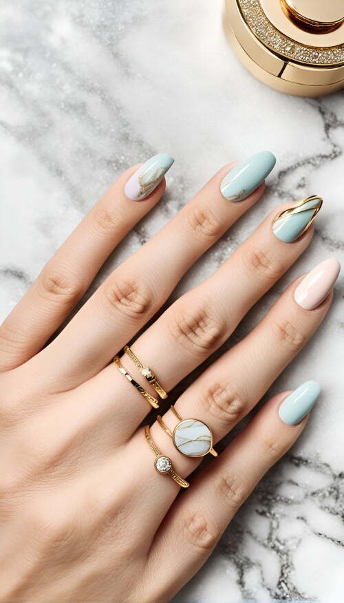 close up of a stylish marble patterned nail design in soft pastel shades featuring gold accents th 8