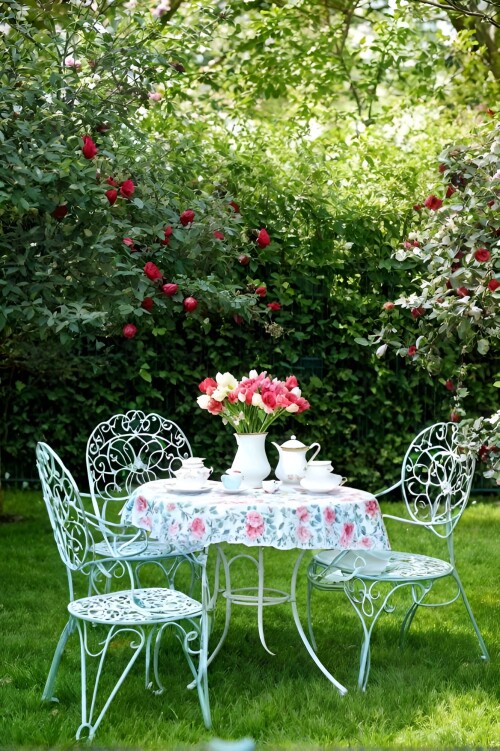 a-sophisticated-springtime-tea-garden-with-a-vintage-wrought-iron-table-and-chairs-adorned-with-del-467988136-1.jpeg